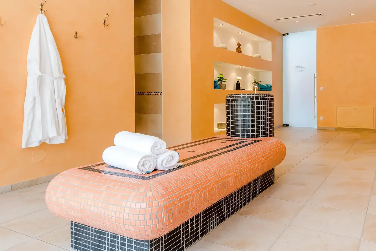 Wellnessbereich im Badehaus mit Liege und Handtüchern