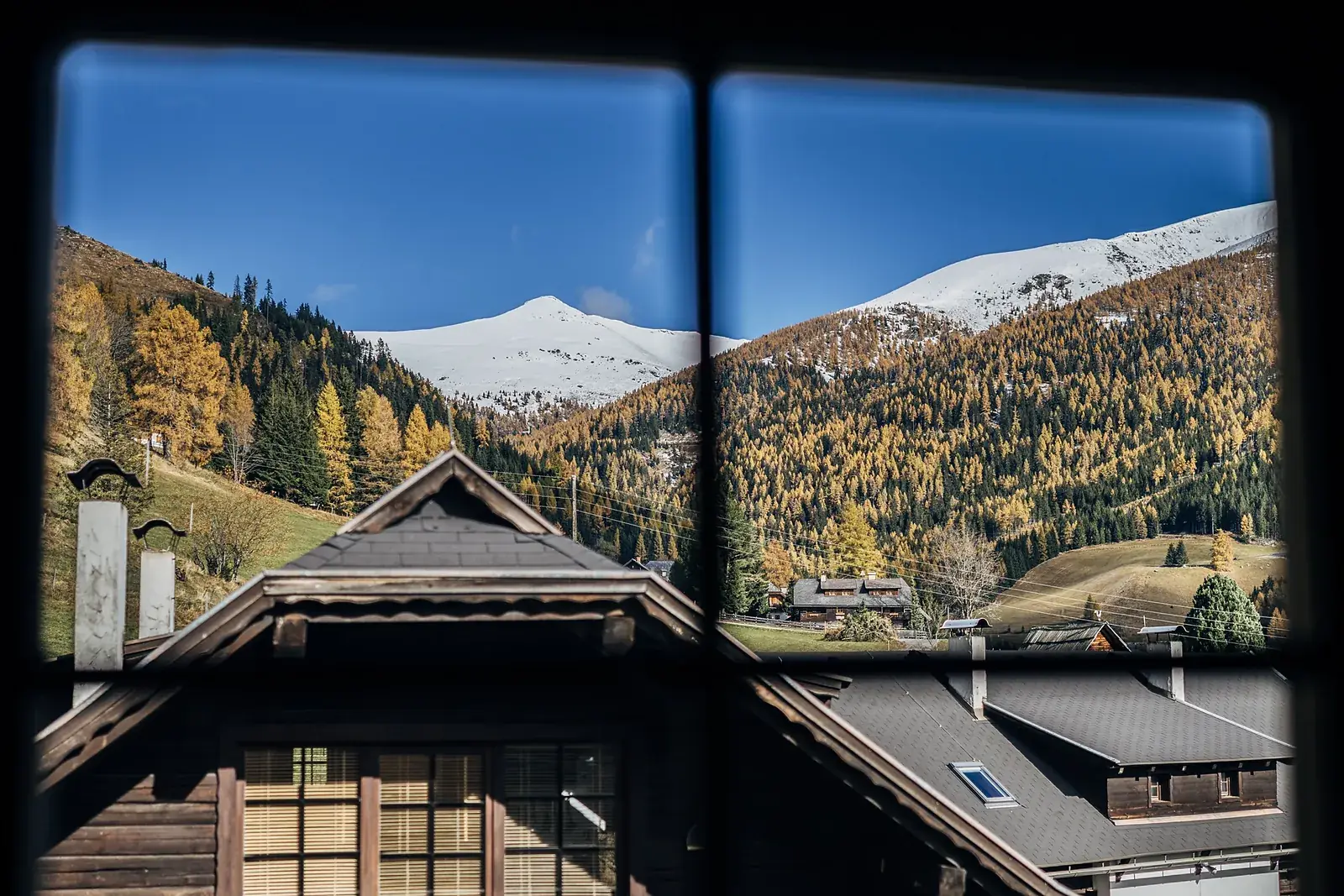 Vista da una finestra su tetti e montagne