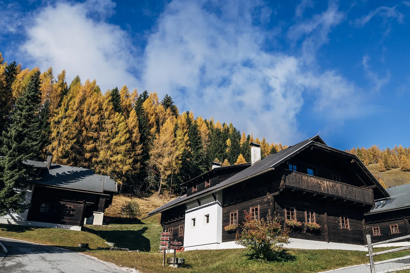 Case Beim Oswald davanti ai larici dorati in autunno